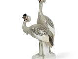 une paire d'oiseaux en porcelaine grise et blanche posés sur une surface blanche