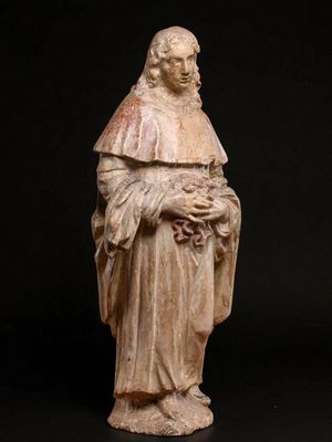 une vieille statue représentant un homme tenant une fleur dans ses mains
