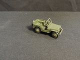 a toy army vehicle on a table with a black background