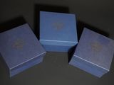 three blue boxes with gold designs on them sitting on a table