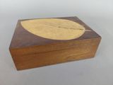 une petite boîte en bois ornée d'une feuille