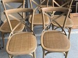 quatre chaises en bois avec des assises en osier dans un magasin