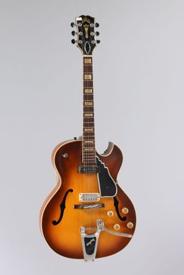 une guitare électrique accrochée à un mur sur fond blanc