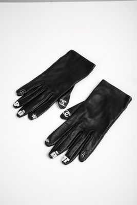 a pair of black leather gloves sitting on top of a white table