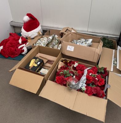 many boxes of christmas decorations and a santa hat on the floor