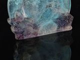 a blue and purple crystal on a black surface