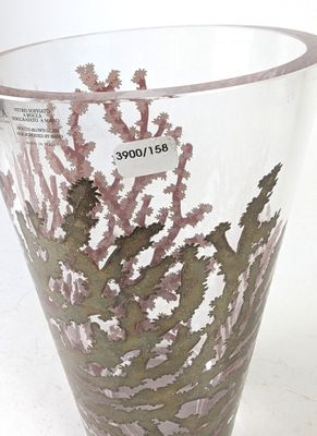 un vase en verre contenant une plante, posé sur une table