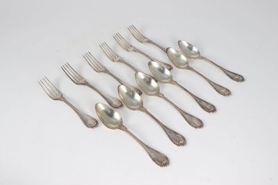 six silver spoons and a fork on a white surface