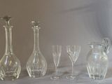 bottles and glasses are lined up on a table with a white background