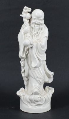 une figurine blanche représentant un homme tenant un oiseau sur un rocher