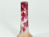 pink and white glass vase with flowers on it on a white surface