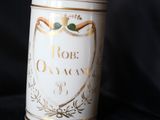 un bidon blanc avec une inscription dorée sur fond noir