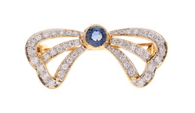 a close up of a diamond and sapphire bow ring