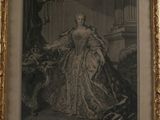 an old picture of a woman in a dress sitting in a chair
