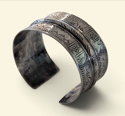 an image of a silver cuff bracelet with a design on it