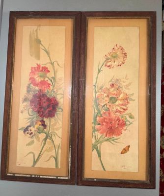 two framed pictures of flowers on the wall in the room