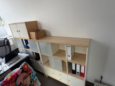 un bureau avec une bibliothèque et une chaise dans un coin