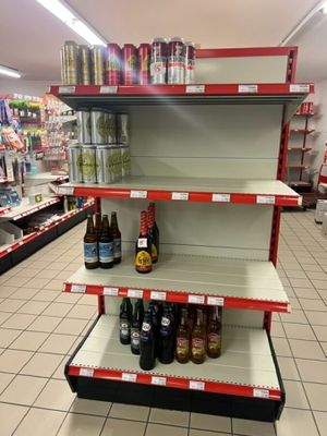 une étagère sur laquelle sont posées plusieurs bouteilles de vin, dans un magasin
