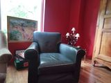 un salon aux murs rouges avec un fauteuil en cuir noir