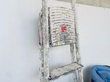 a ladder leaning against a wall next to a pile of boxes