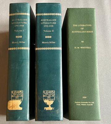 trois livres verts posés les uns à côté des autres sur une table