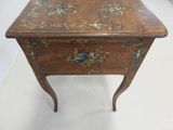 a small wooden table with a floral design on it