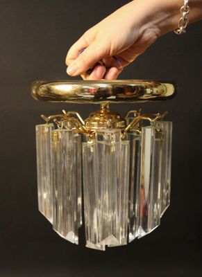 a person holding a glass chandelier in their hand