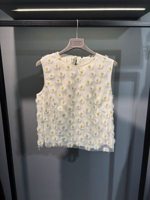 un haut blanc suspendu à un cintre dans une vitrine