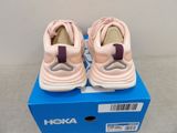 pink and white sneakers are on a blue box on a gray surface