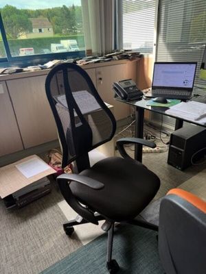 un bureau avec un ordinateur et une chaise dans une pièce