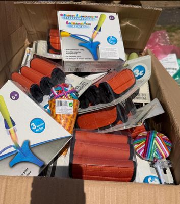 une boîte en carton remplie de fournitures scolaires et une paire de ciseaux