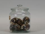 a glass jar with eggs inside of it on a white surface