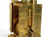 a gold clock that is sitting on top of a stand