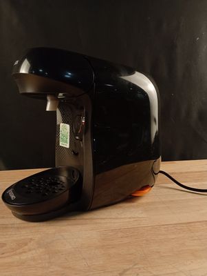 a black coffee maker sitting on a wooden table