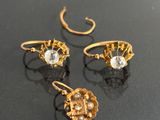 two pairs of gold earrings and a ring with a diamond