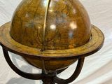 an old globe on a stand on a rug with a white background