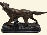 bronze statue of a dog standing on a rock with its mouth open