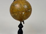 an old wooden globe on a black stand with a white background