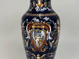 a blue and gold vase sitting on a white surface