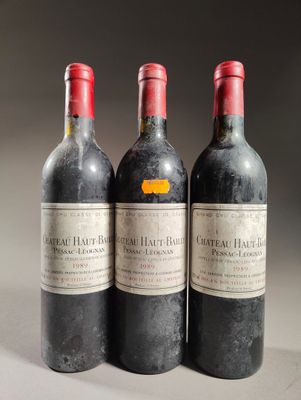 trois bouteilles de vin rouge sont alignées sur une table