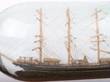 a glass bottle with a ship in it on a table