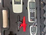 une mallette noire contenant des outils, posée sur une table