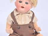 doll with blonde hair and overalls sitting on white surface