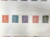plusieurs timbres de différentes couleurs sur une feuille de papier où l'on voit une personne en train de marcher