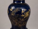 a blue vase with a gold dragon on it on a table