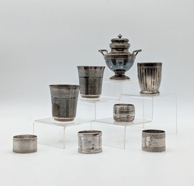 several silver vases and cups sitting on a clear shelf