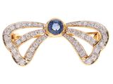 Gros plan sur une bague en forme d'arc sertie de diamants et de saphirs