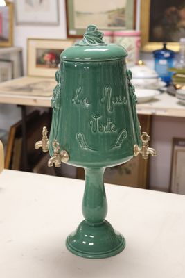 a green vase sitting on a table in a room