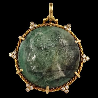 a close up of a pendant with a face of a woman