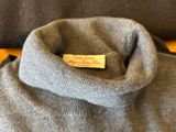 the back of a gray sweater with a label on it